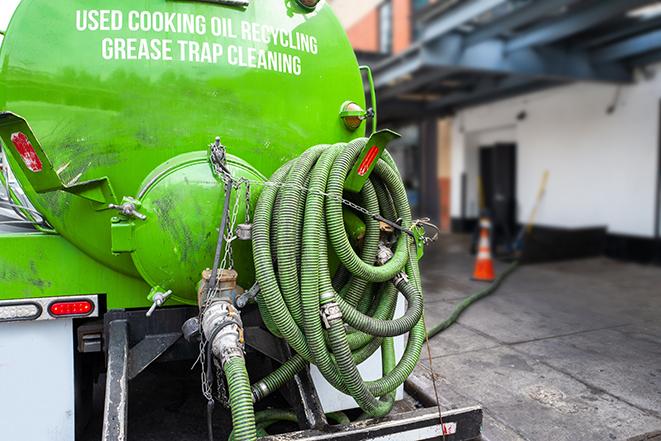 a technician pumping a grease trap in a commercial building in Vinton